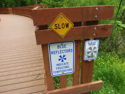 Sign on boardwalk - blue reflectors indicate freezing temperatures - slow
